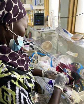 Barnsjukvård i Uganda. Sjuksköterska vårdar barn i kuvös.