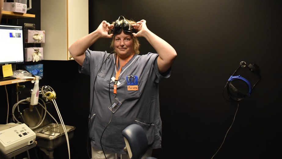 Undersköterskan Mariana Hansson håller upp och tittar på sin tumme genom ett par svarta specialglasögon.