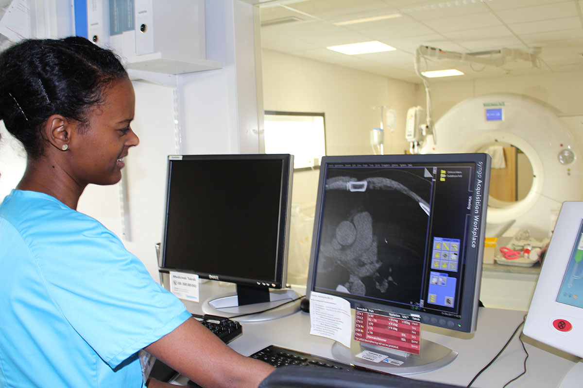 En person visar röntgenbild på datorskärm.