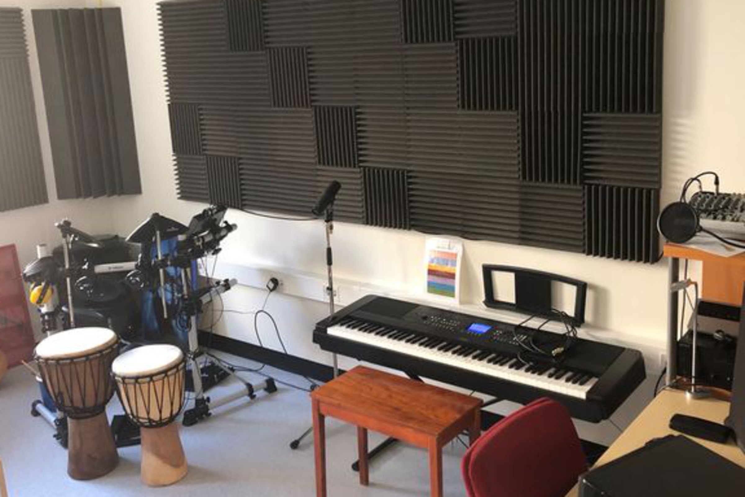 Musikrum med olika musikinstrument som trummor och piano mm.